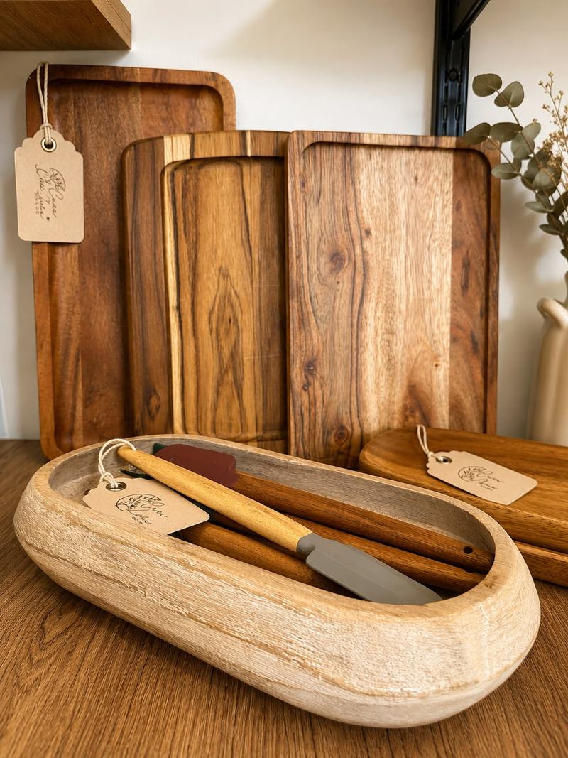 Bandejas de madera oscura de distintos tamaños y un cuenco de madera clara con utensilios, con etiquetas de papel de Casa Luma.