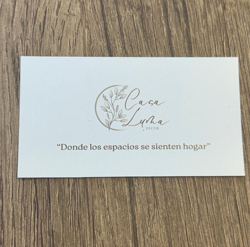 Tarjeta de Casa Luma sobre una mesa de madera, con el logo y la frase: Donde los espacios se sienten hogar.